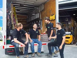 Équipe souriante chez Portes Universelles dans un camion de service